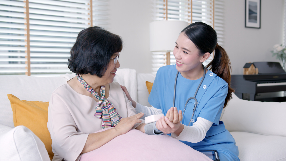 A female nurse checks the blood pressure of a senior woman.